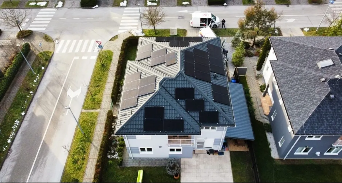 Solarni paneli prilagođeni složenoj geometriji krova obiteljske kuće u uređenom naselju.